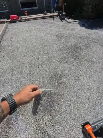 A resin sample held out over an old drive to match the stone to the job