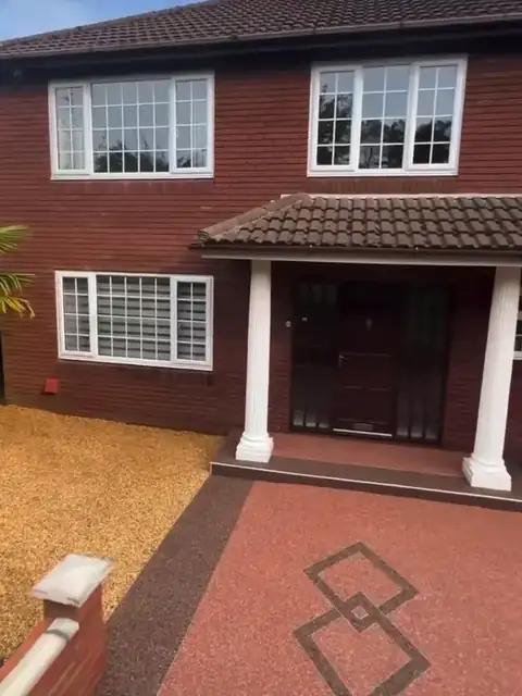 The finished terracotta drive and its inlay in front of a red brick house